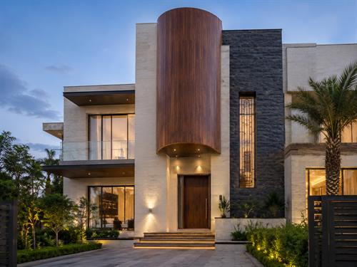 Modern villa with a curved timber-clad entrance tower